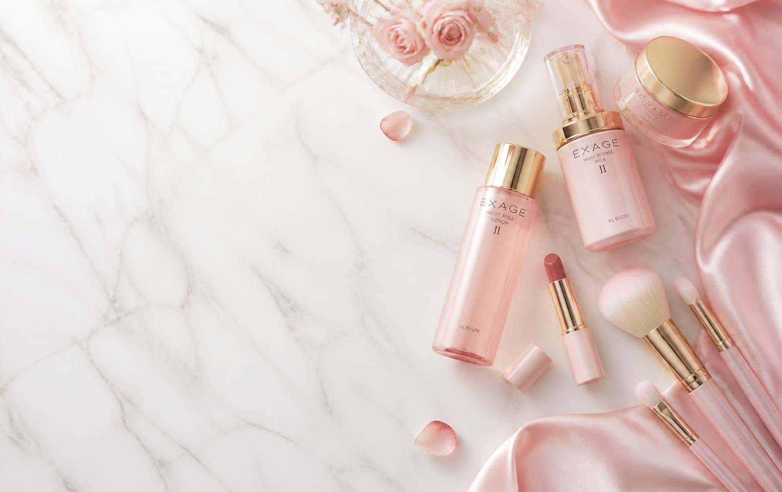 Produtos de beleza em tons de rosa e dourado sobre mármore